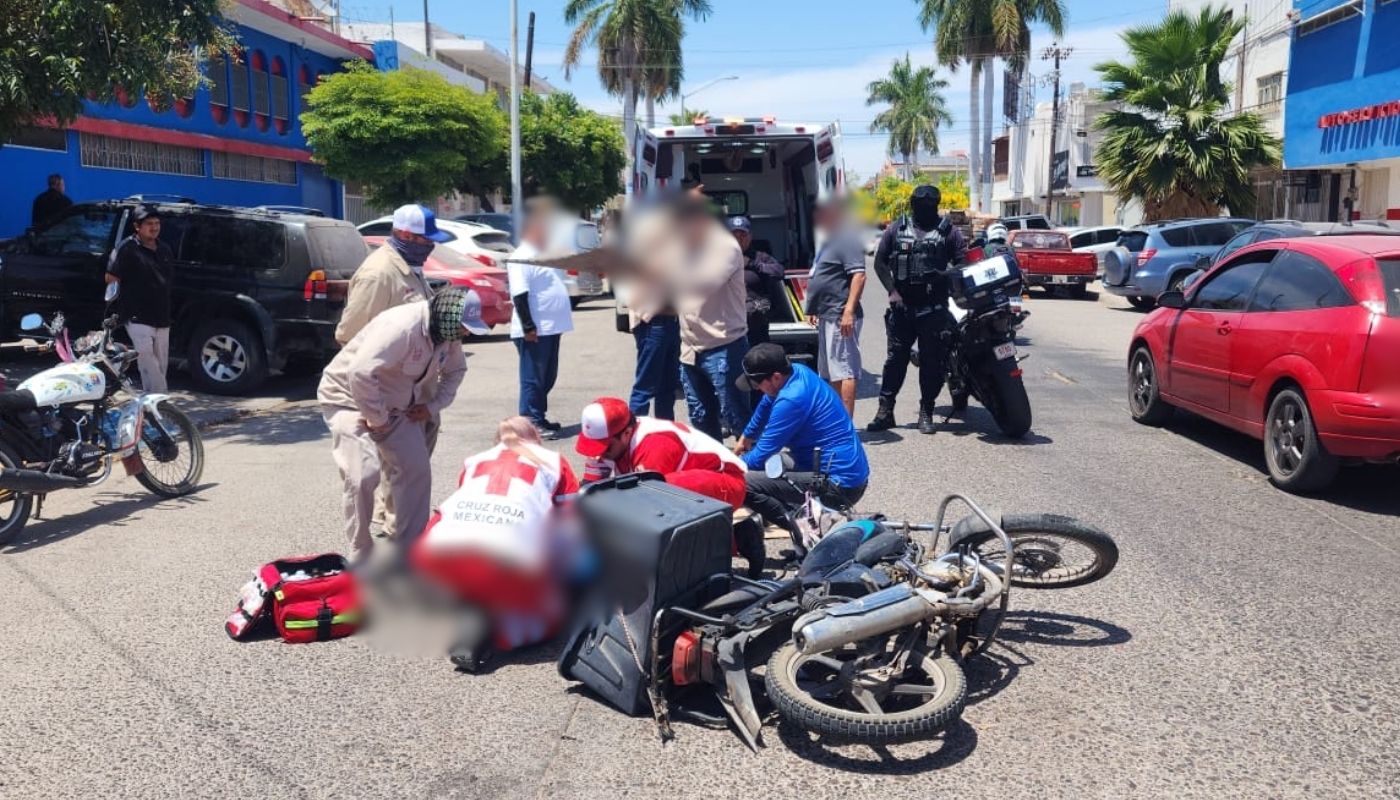 Paramédicos de la Cruz Roja junto a un motociclista tirado en la calle