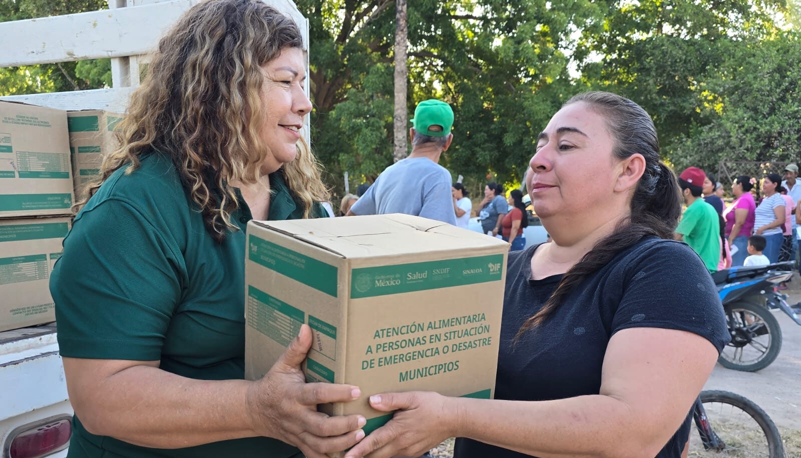 Dos personas con una caja junto a una camioneta