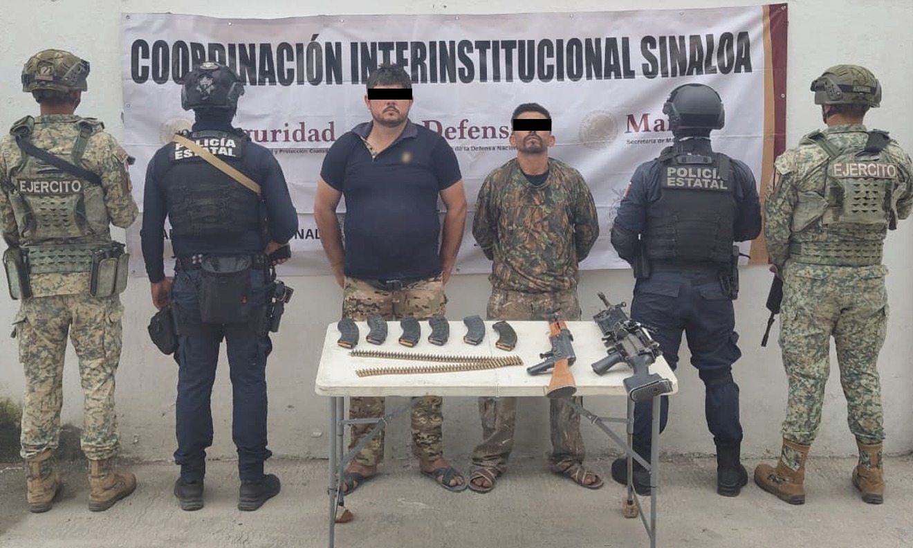 Dos elementos de seguridad con armas aseguradas