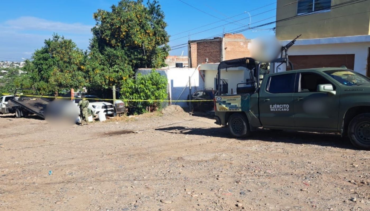 Camioneta del Ejército Mexicano junto a una camioneta blanca y cinta amarilla