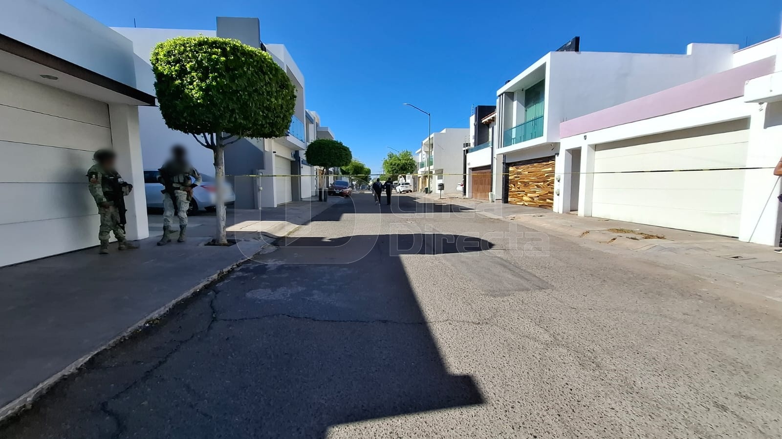 Agentes policiacos desplegados en una calle con una cinta amarilla de precaución