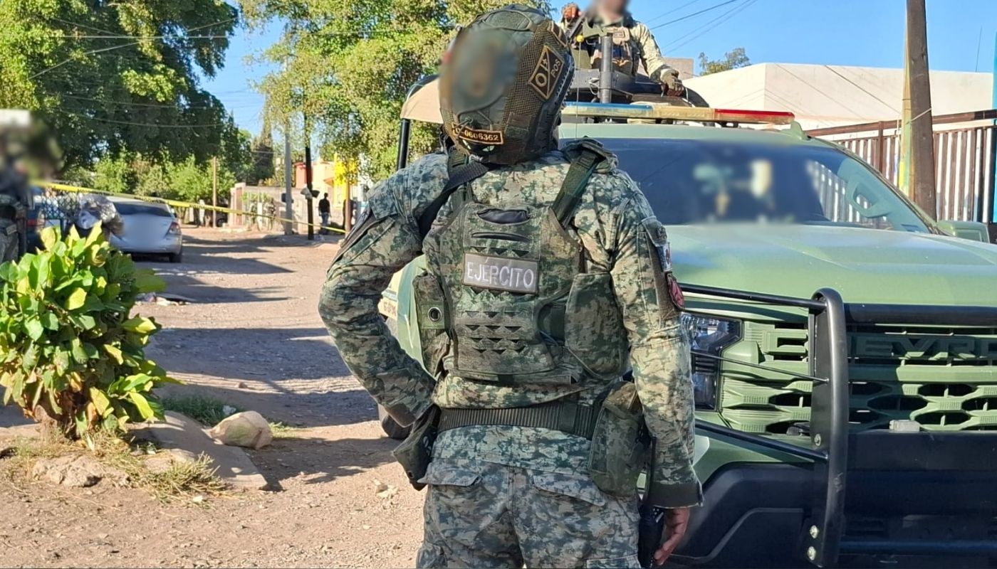 Elemento del ejército mexicano de espaldas con cinta amarilla frente a el