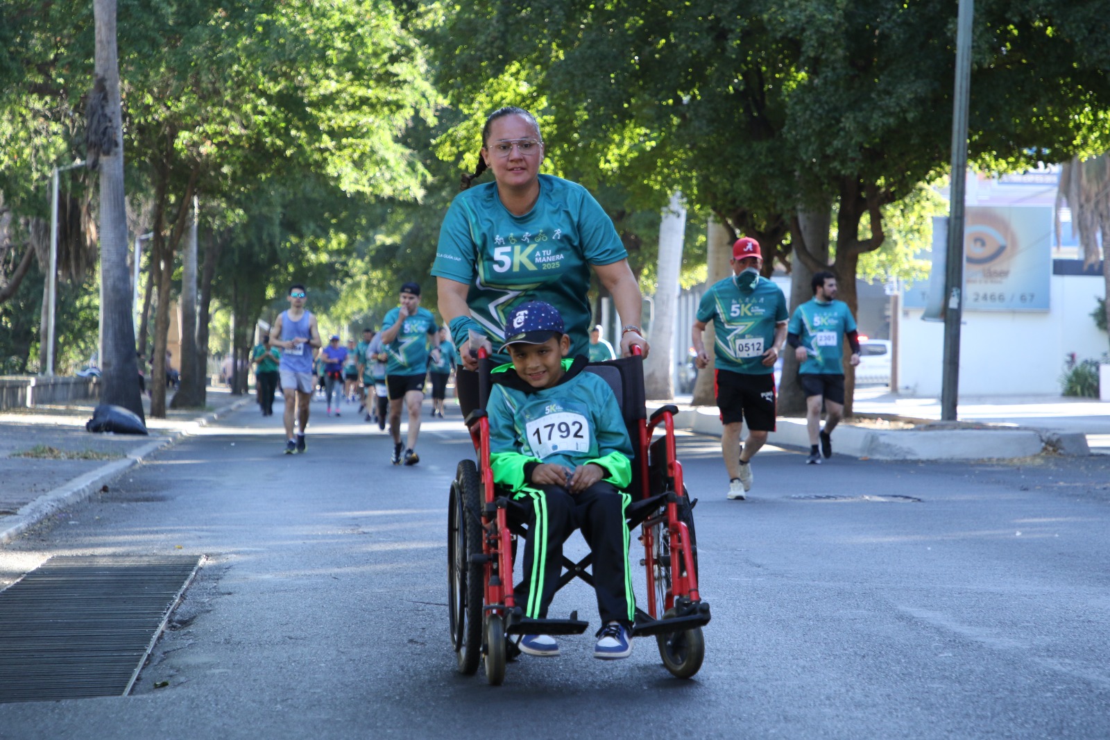 persona corriendo junto a un niño en silla de ruedas en una carrera