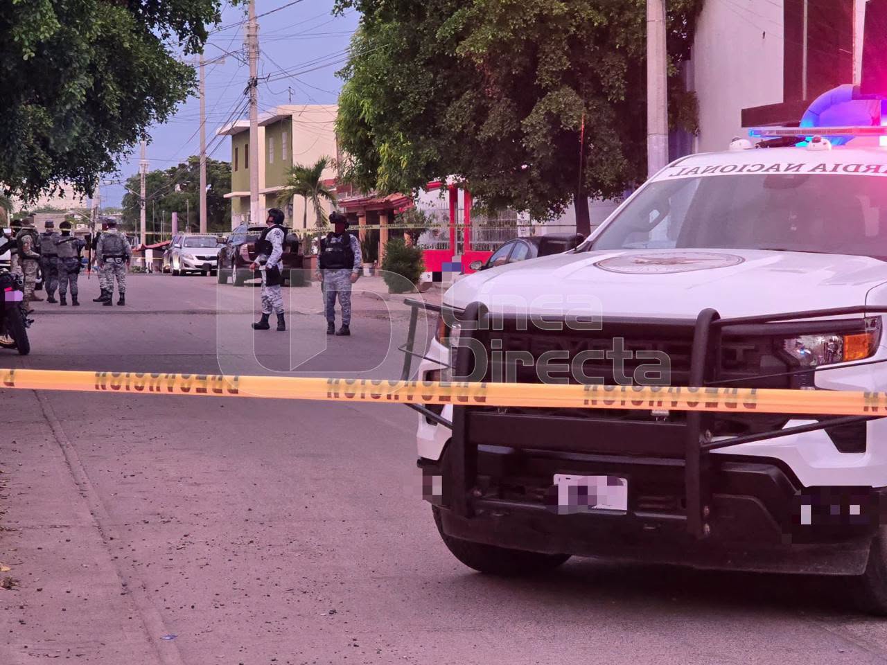 unidad y elementos de la Guardia Nacional en una calle con una cinta de precaución