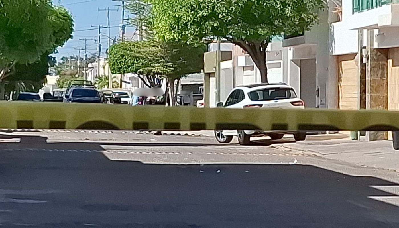 Cinta amarilla de precaución y al fondo una calle y carros
