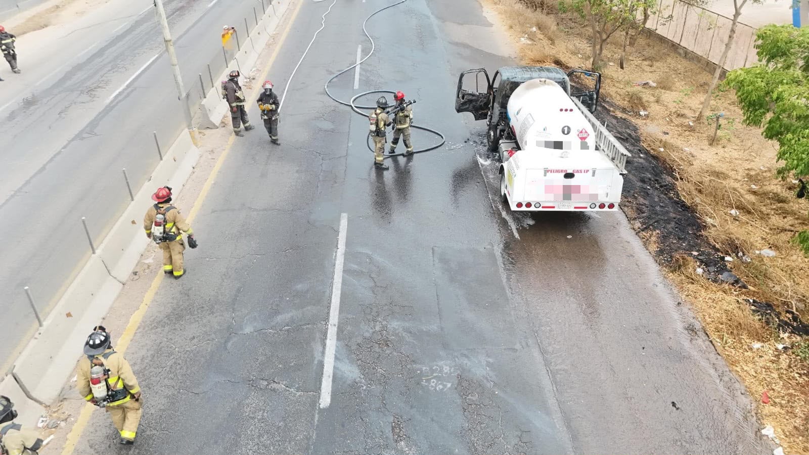 Bomberos combatiendo el incendio de la pipa de gas.