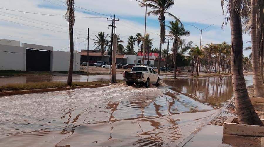 Agua estacntada en una calle con una camioneta pasando