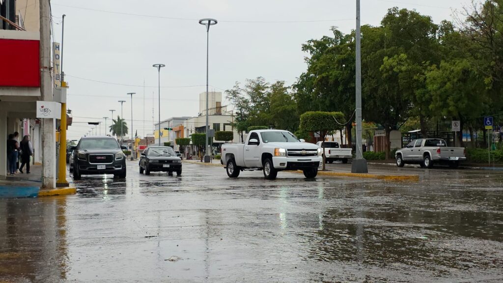 Calle mojada con una camioneta blanca