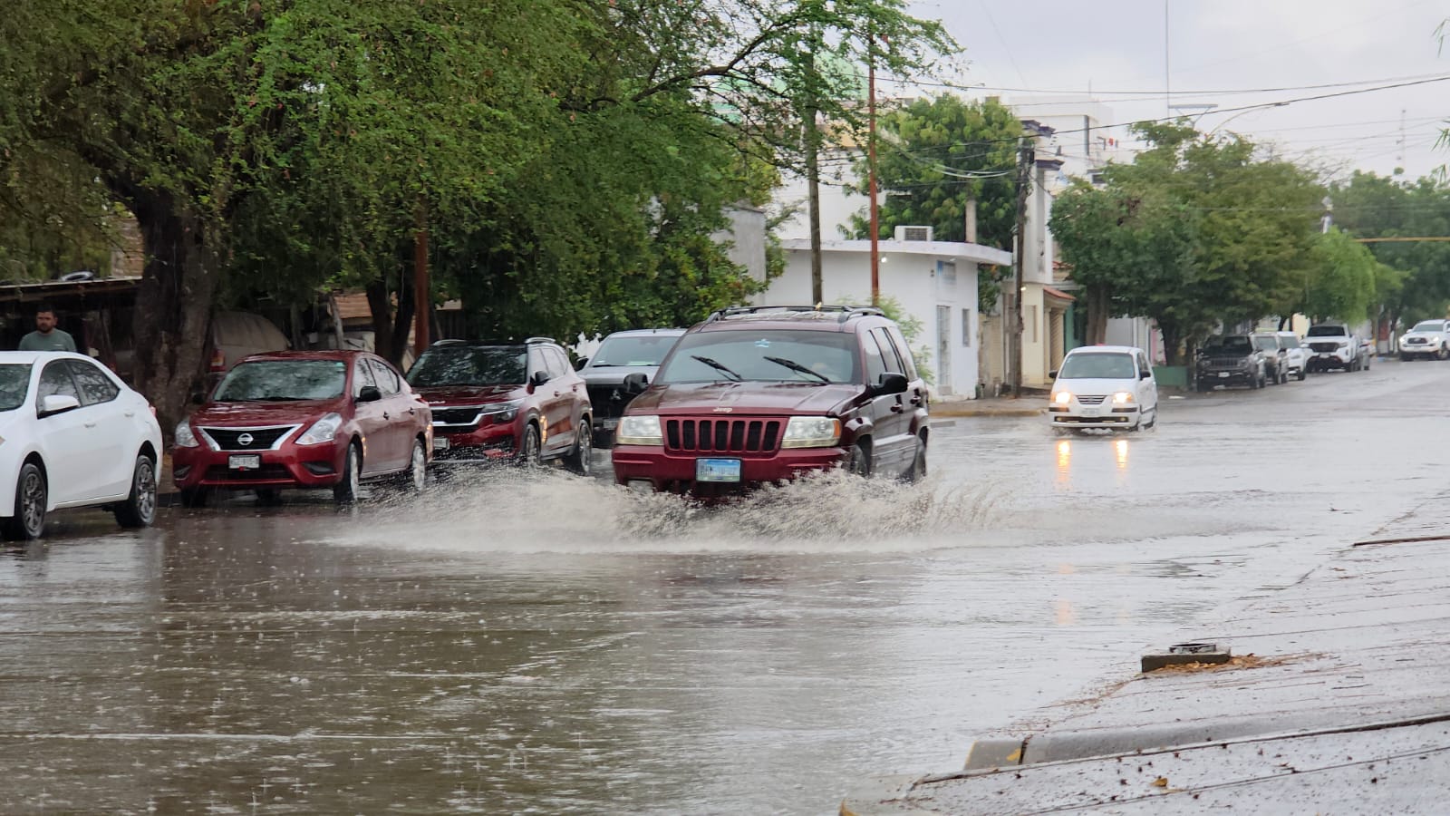 Camioneta tinta con la calle inundada y agua de lluvia