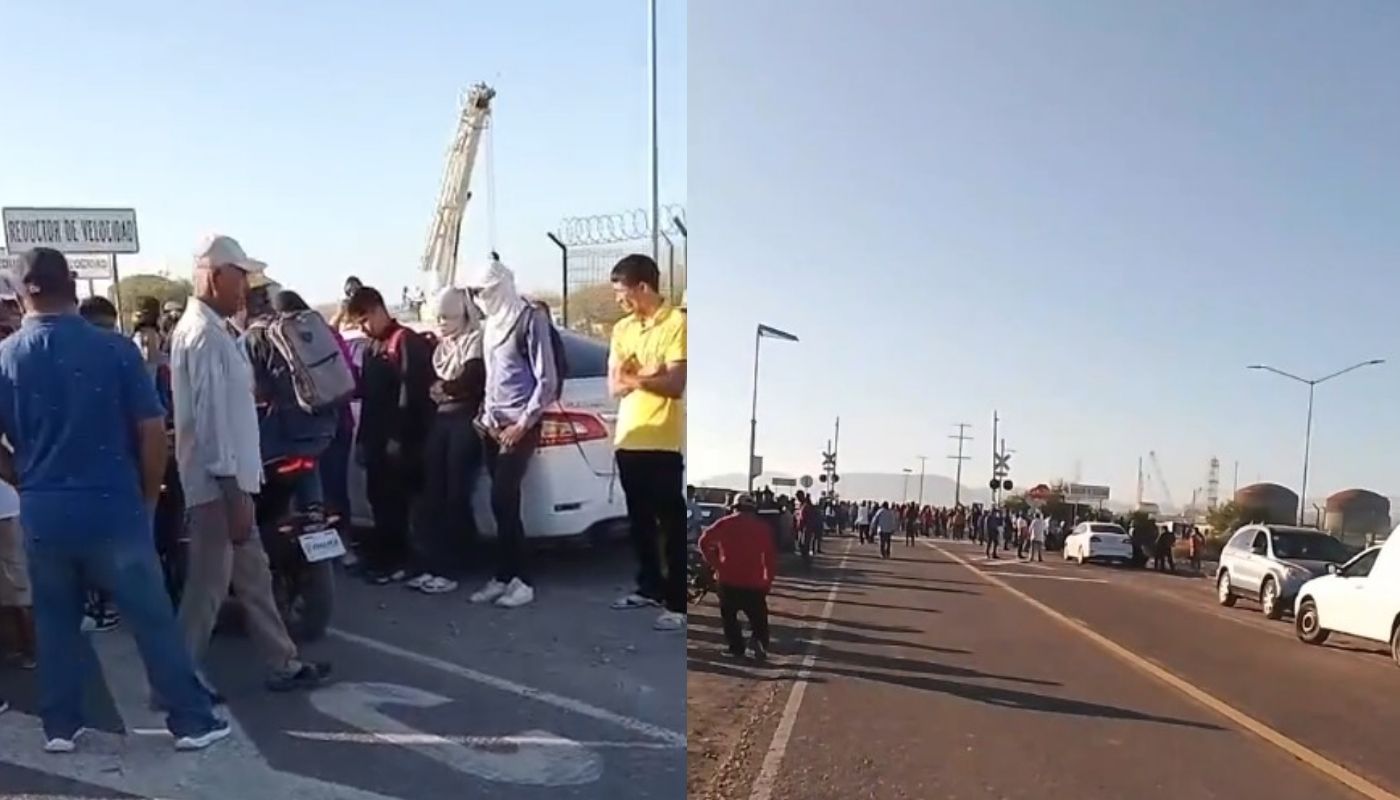 Personas bloqueando la calle con carros y motocicletas