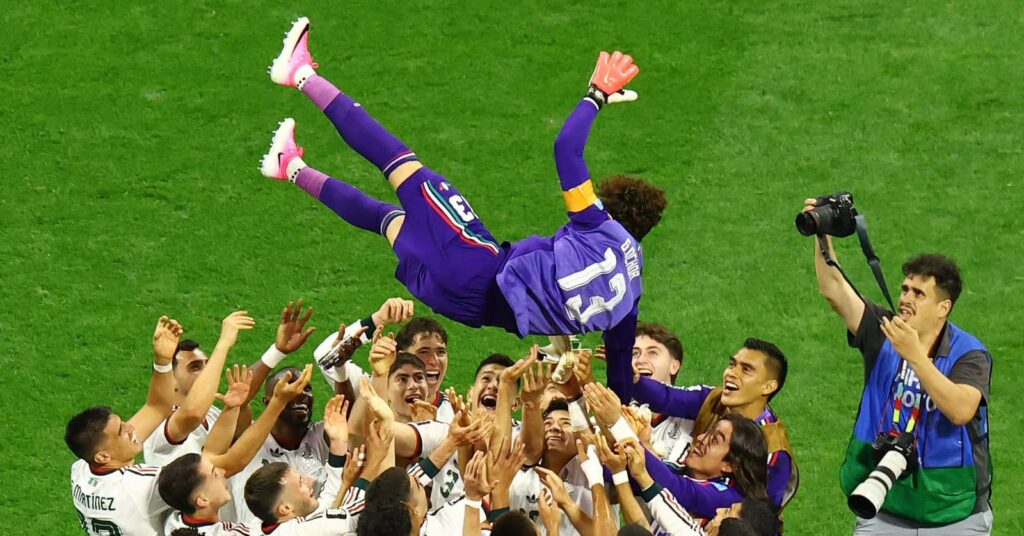 “Memo” Ochoa en el aire mientras los miembros de la selección lo levantan en una celebración.