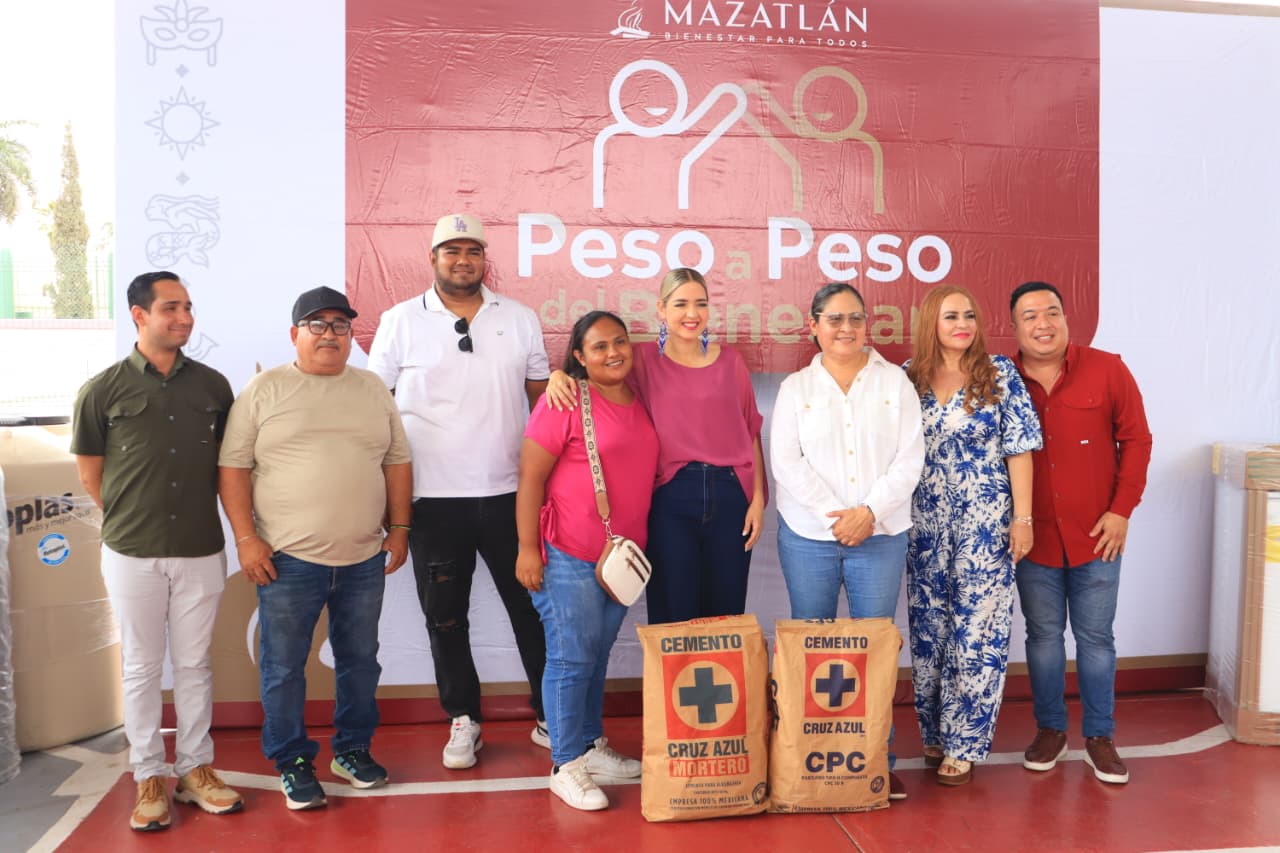Alcaldesa de Mazatlán junto a personas abrazadas y un costal de cemento