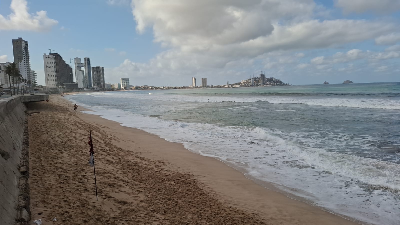 playa con olas y banderas en la arena