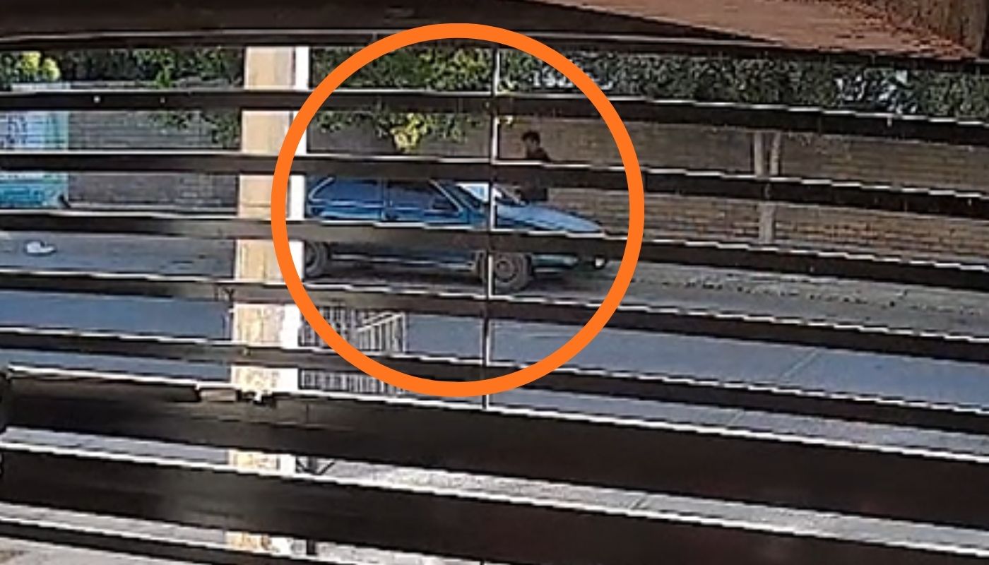 Carro con una persona y un circulo con líneas en un porton