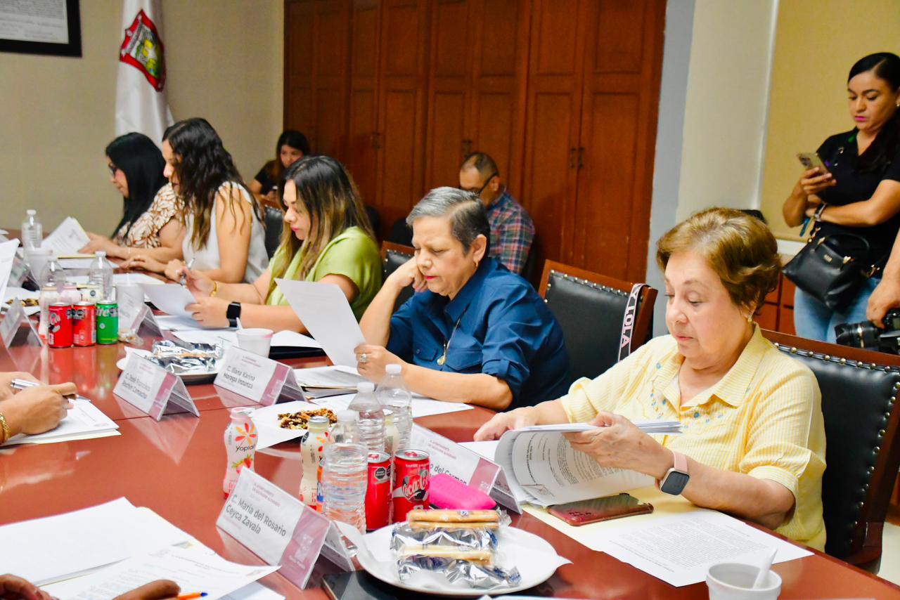 Personas en una reunión del Ayuntamiento, revisando papeles