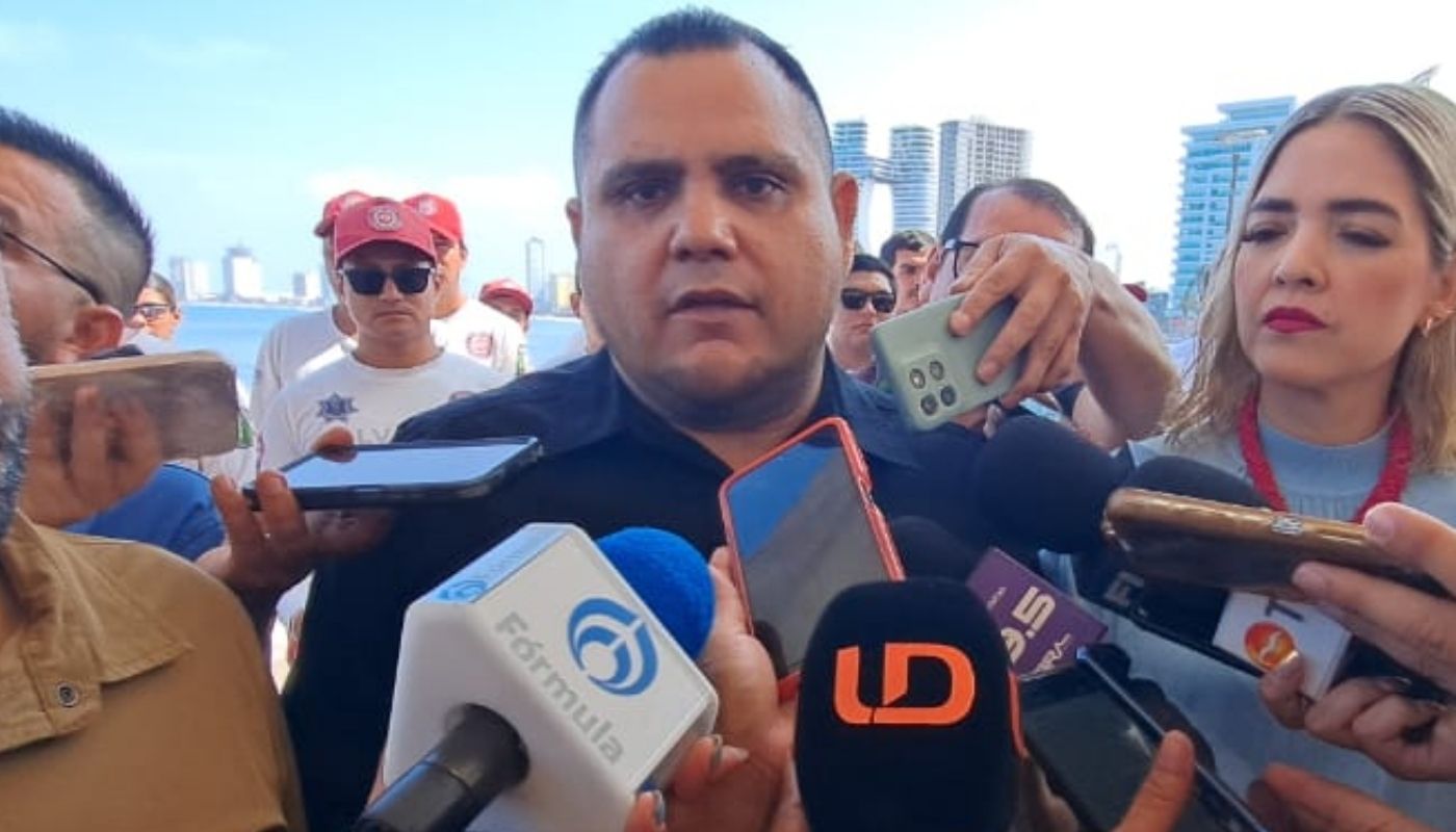 Jaime Othoniel Barrón Valdez con micrófonos junto a la alcaldesa de Mazatlán