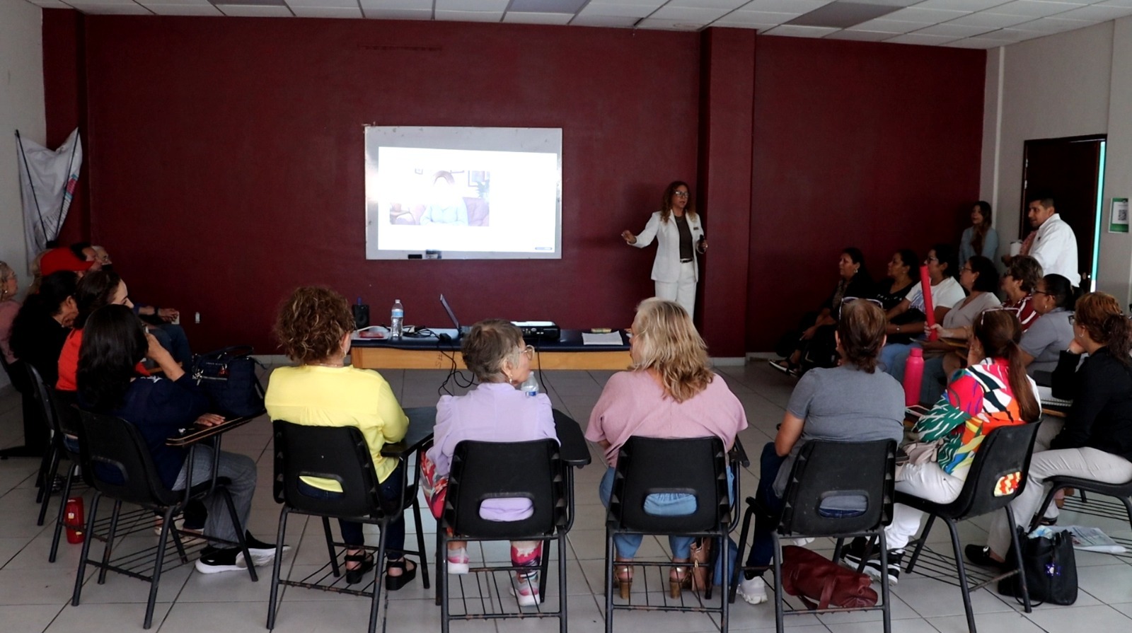 Personas en una reunión con una pantalla con diapositivas