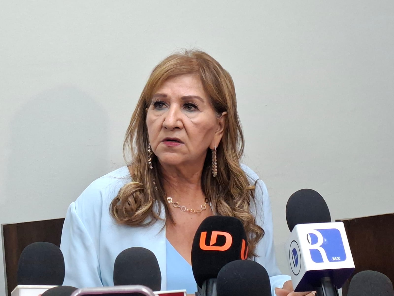 Tere Guerra con micrófonos de la prensa