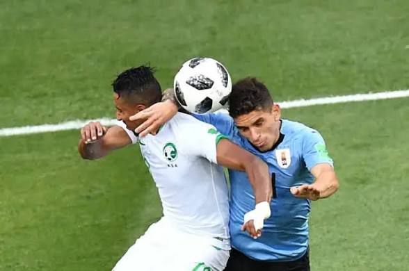 Un jugador de Arabia junto a uno de Uruguay y la pelota del Mundial 2018