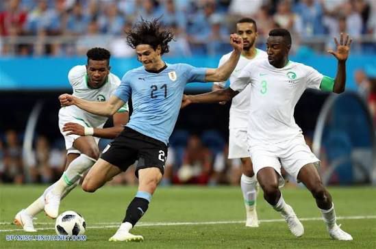 Tres jugadores de Arabia junto a Cavanni de Uruguay
