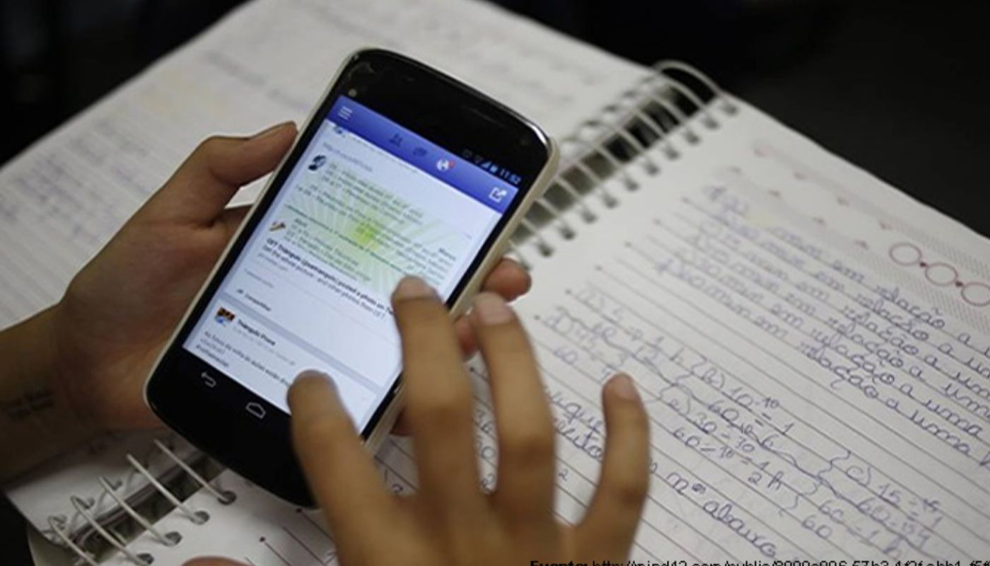 Celular con una libreta detrás