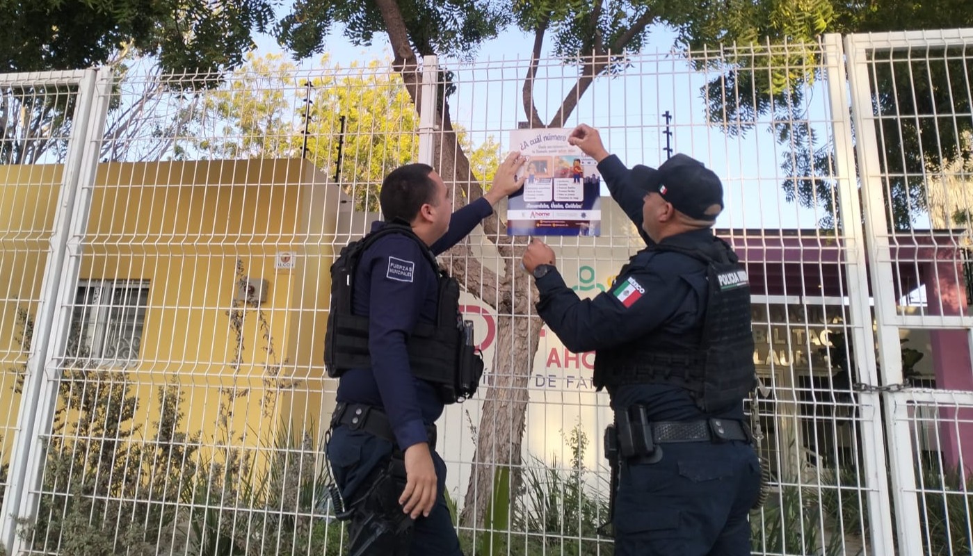 autoridades colocando folletos informativos de seguridad en el cerco de una casa