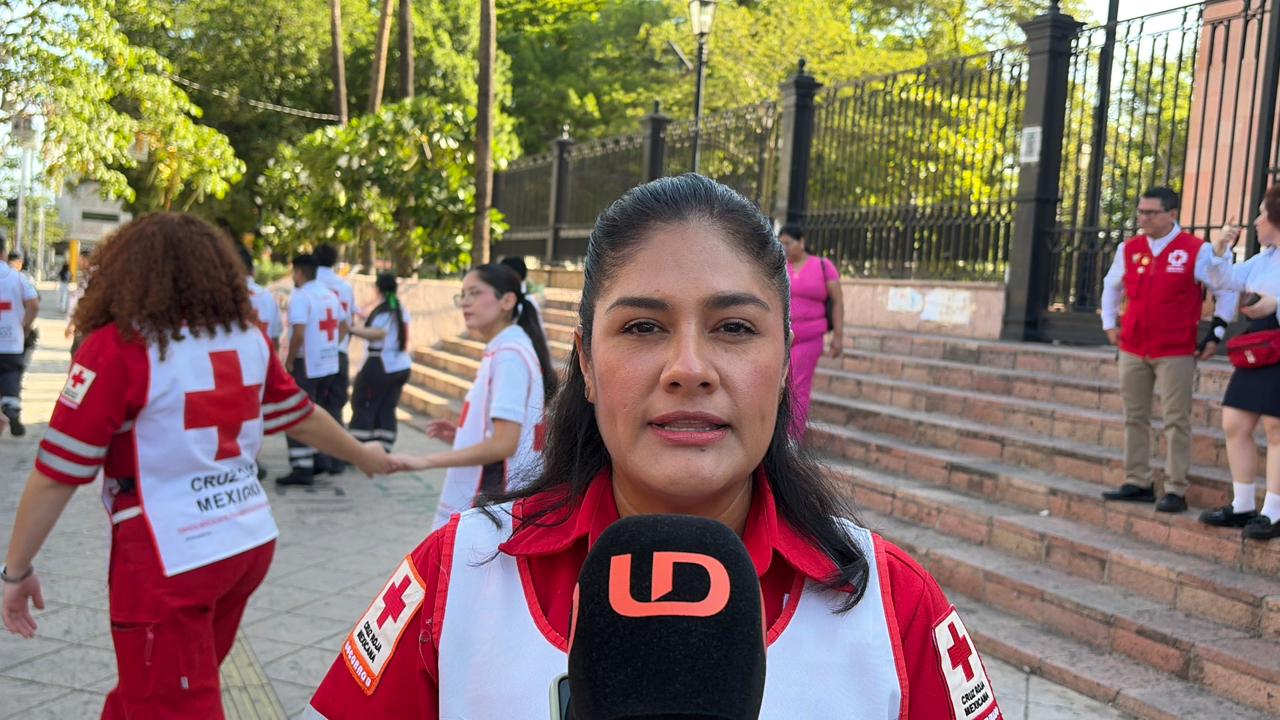 socorrista de la Cruz Roja viendo hacia el frente con un micrófono