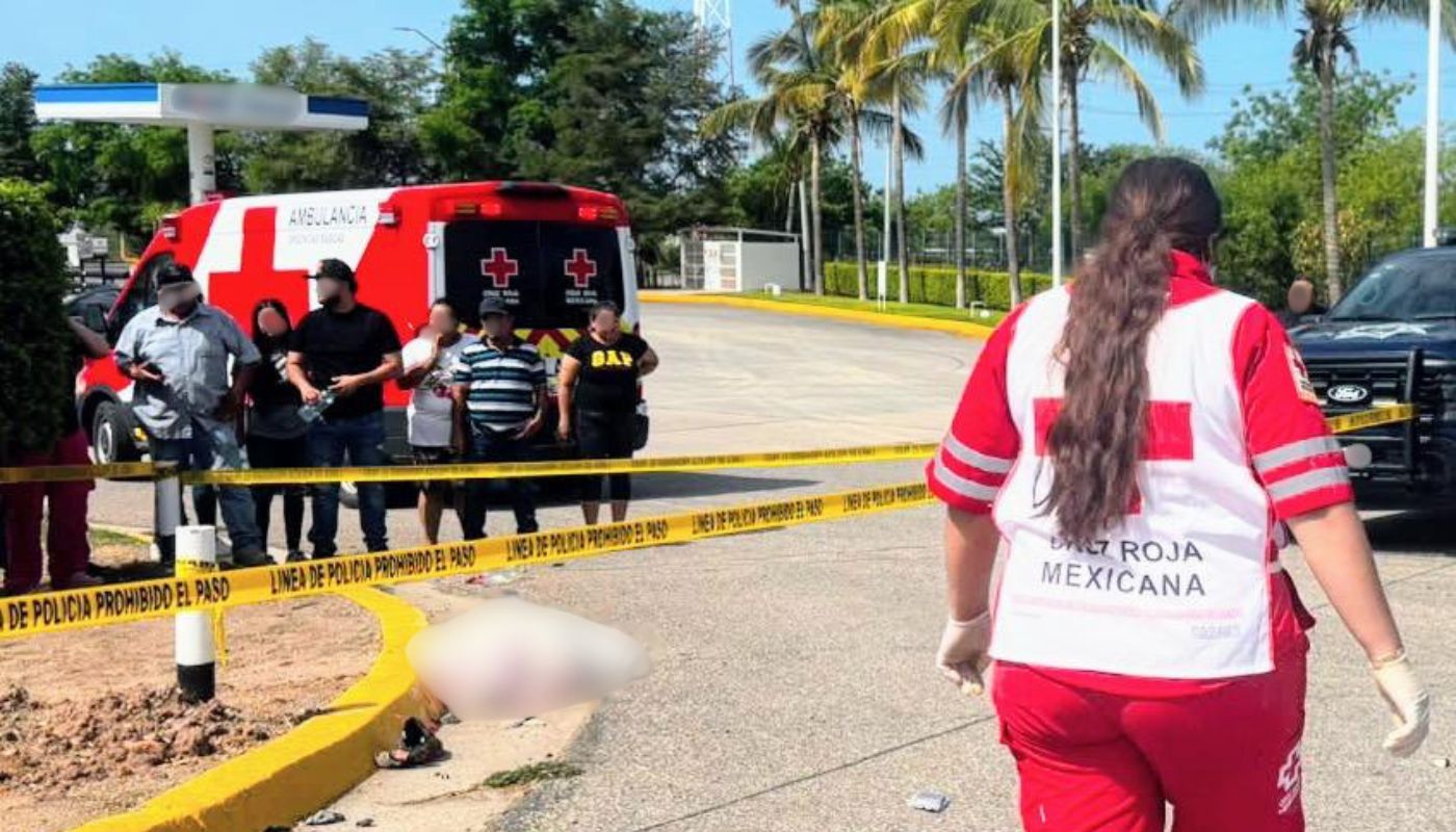 Personal de Cruz Roja y una unidad al fondo, una cinta amarilla de precaución y personas