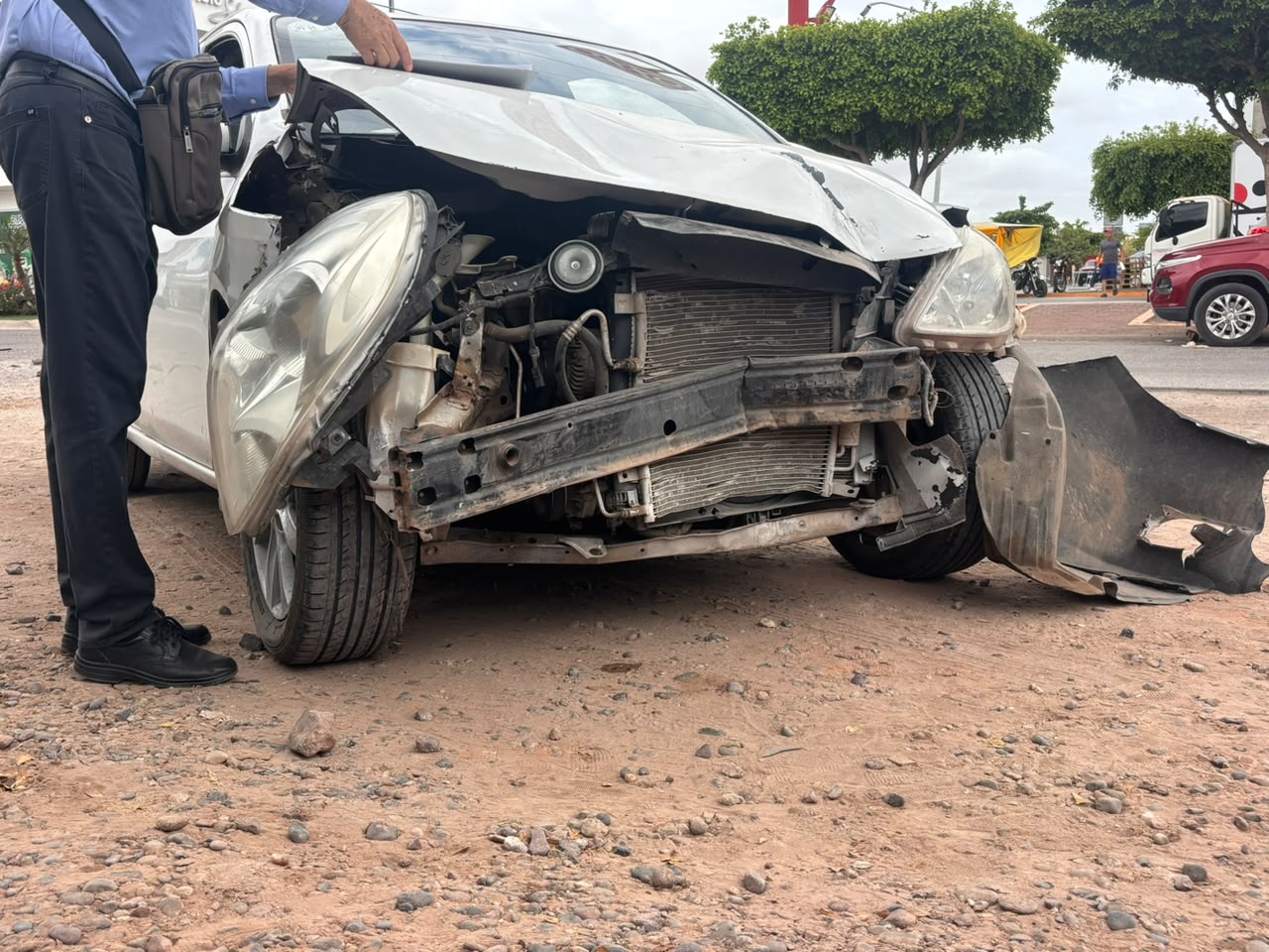 Carro particular de color blanco con un impacto al frente luego de un choque