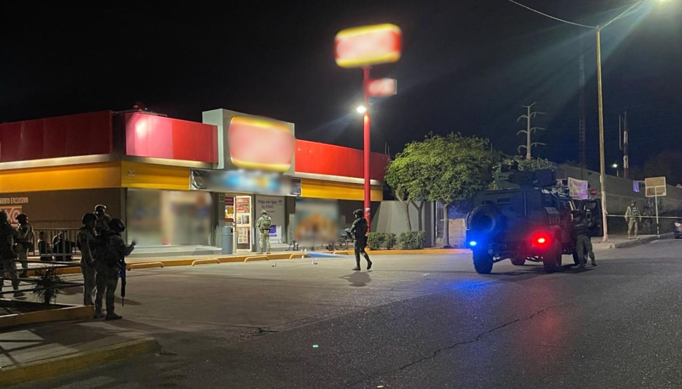 Elementos militares afuerda de una tienda de conveniencia durante la noche