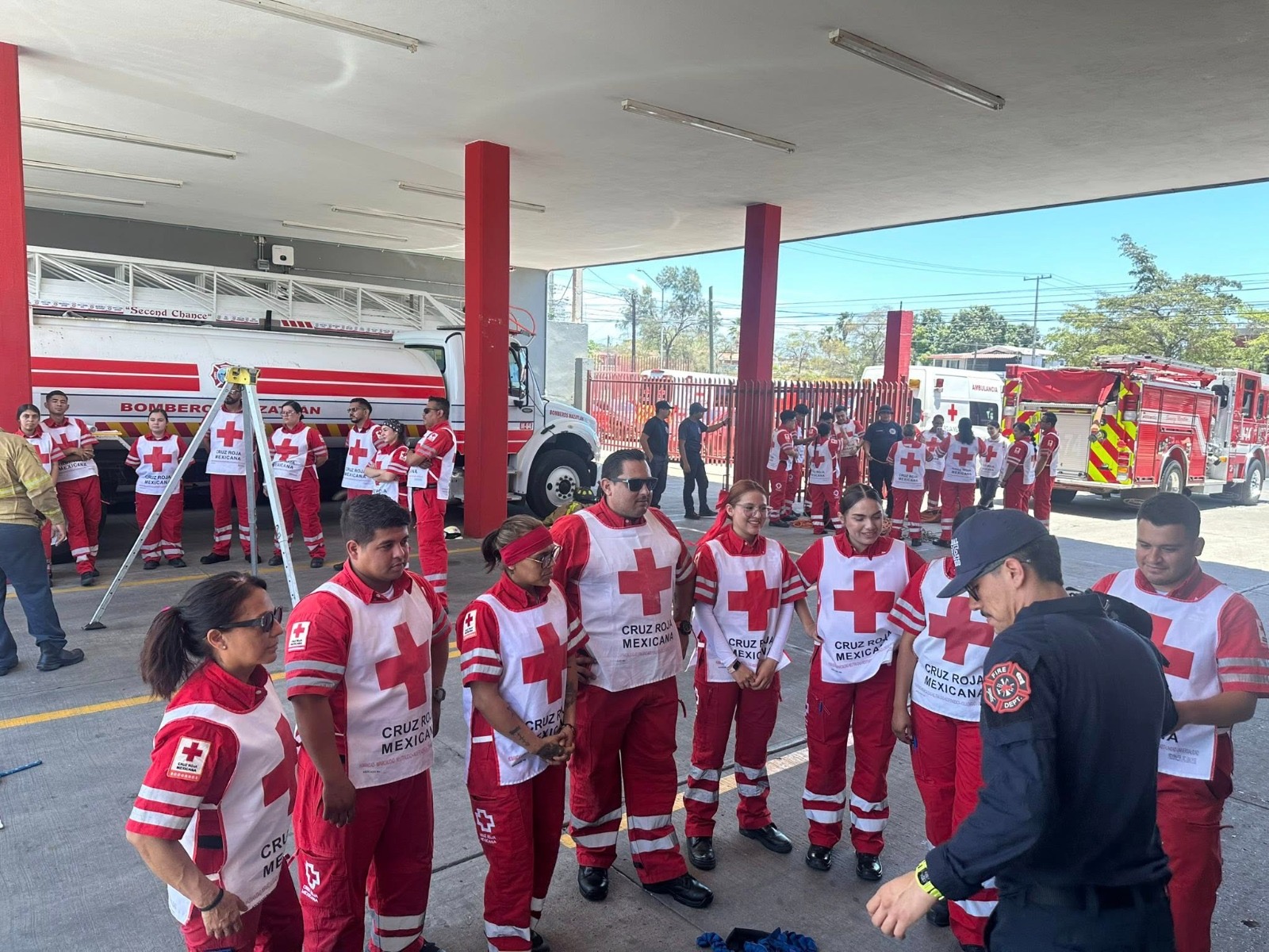 Personal de Cruz Roja detrás de ellos con una ambulancia