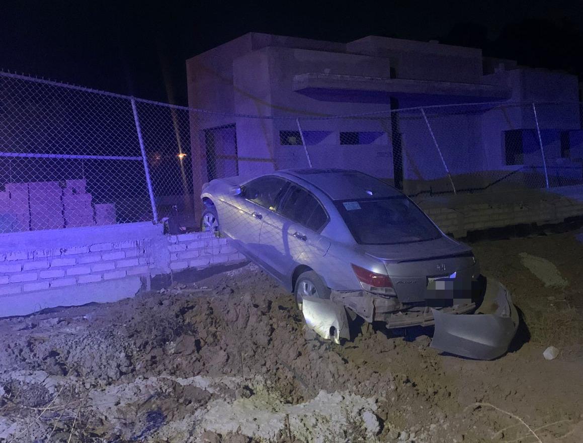 Carro de color negro impactado contra una cerca tras un choque