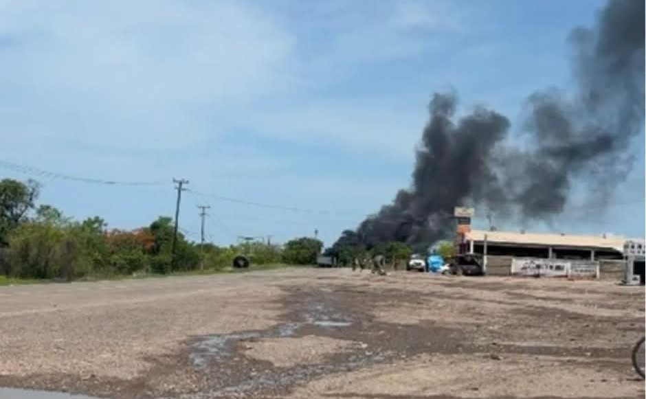 Calle y un establecimiento al fondo con una nube de humo negro