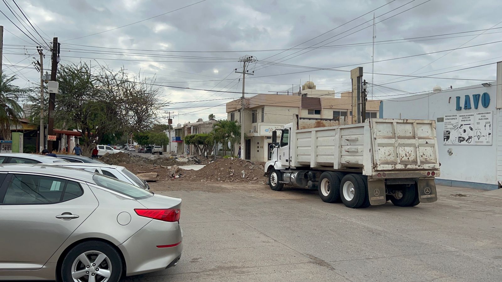 Calle con una montaña de tierra entre carros