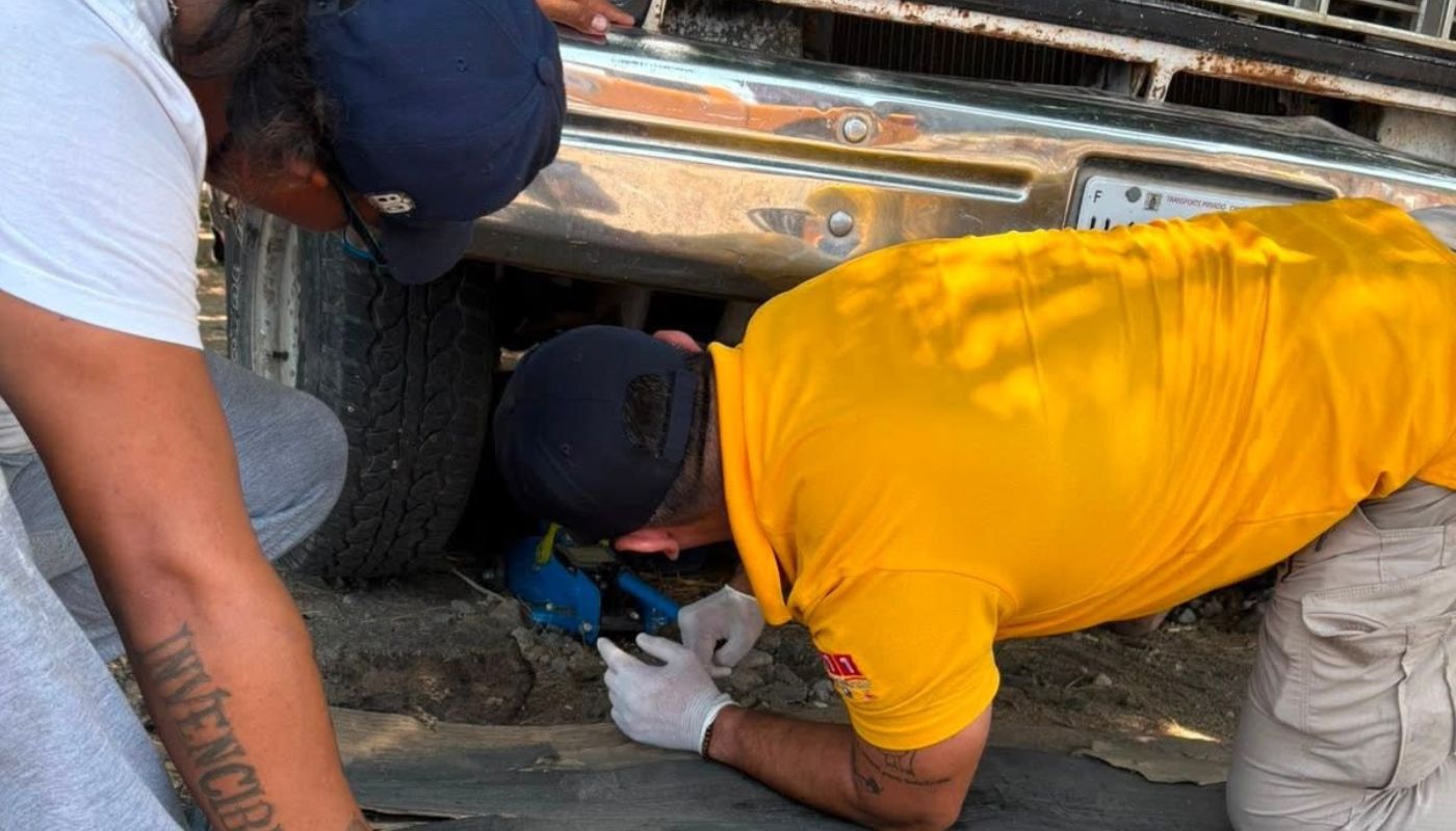 Persona atrada bajo un carro