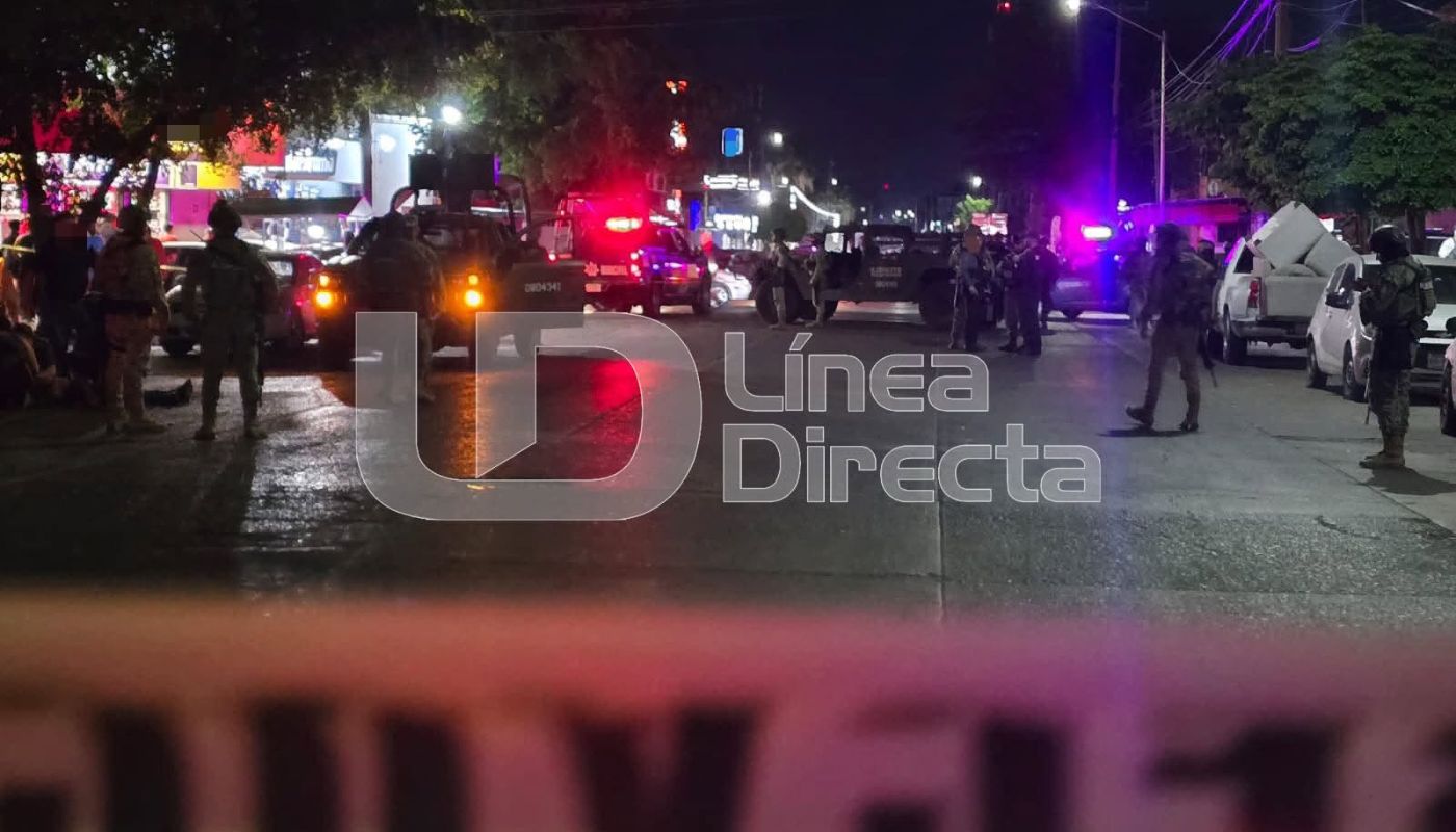 Cinta amarilla de precaución en una calle con elementos policiacos y unidades desplegadas en la zona