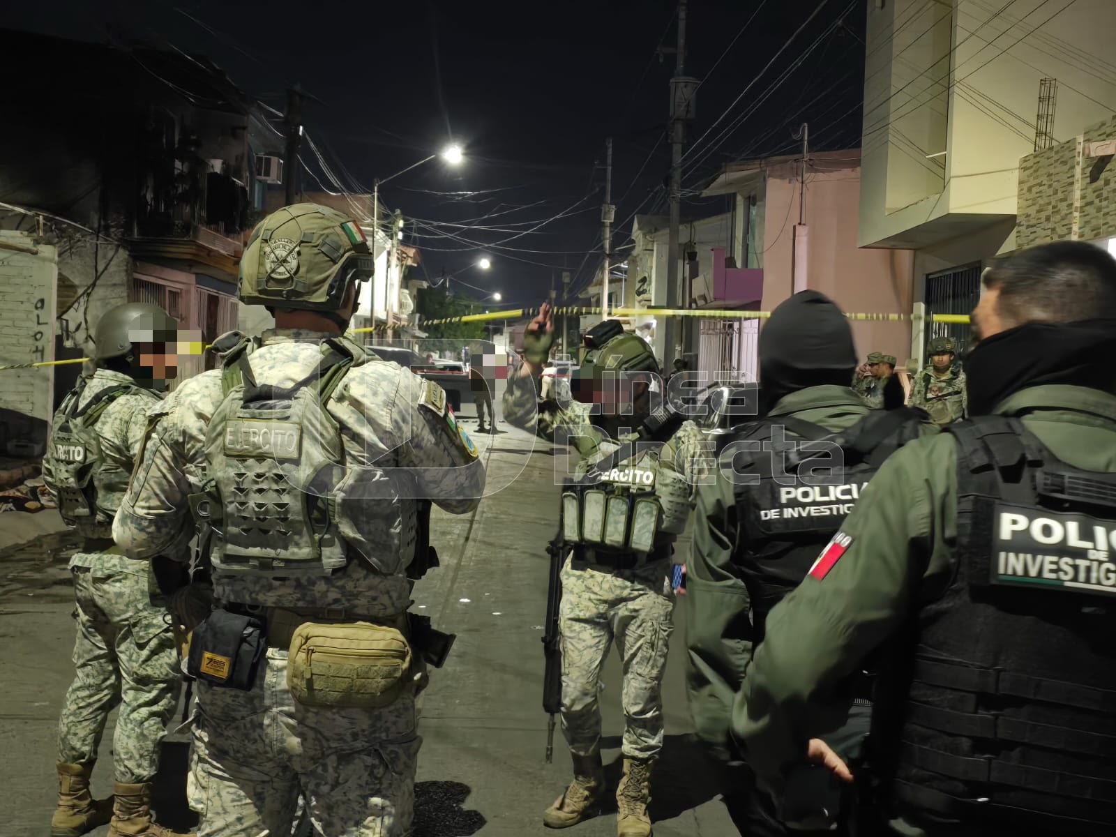 Elementos del Ejército Mexicano en una calle con una cinta de precaución