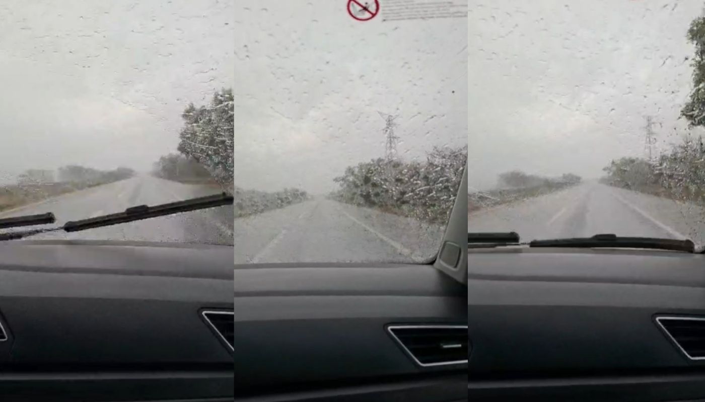 Vidrio de un carro mojado por la lluvia, en una carretera
