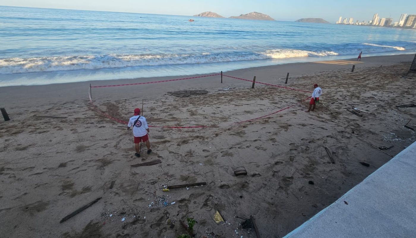 Elementos de cuerpos de emergencia en una playa frente al mar en Mazatlán