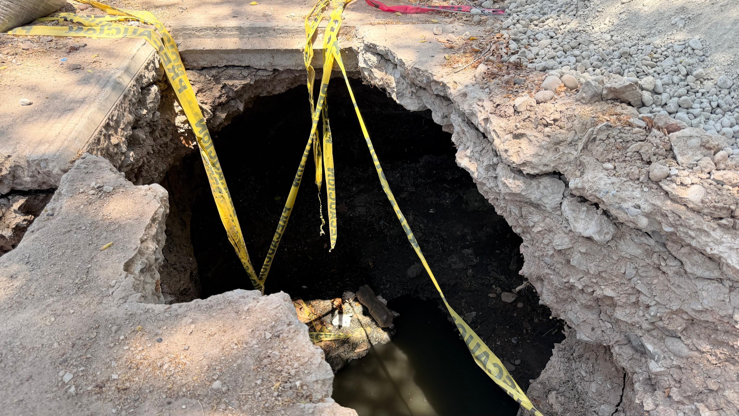Socavón con cintas amarillas de precaución