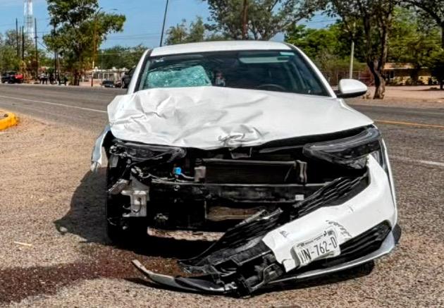 Automovil de color blanco con un impacto en la parte frontal tras un choque, en una carretera