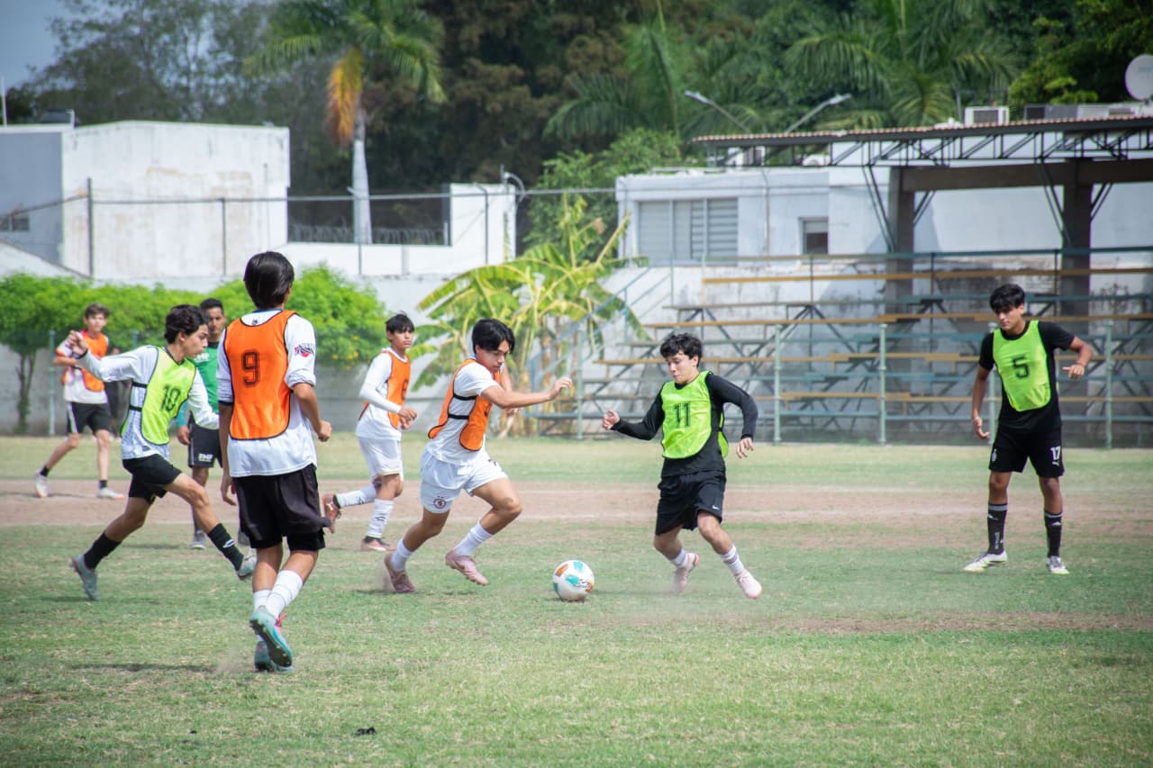 Jóvenes entrenando futbol en un campo