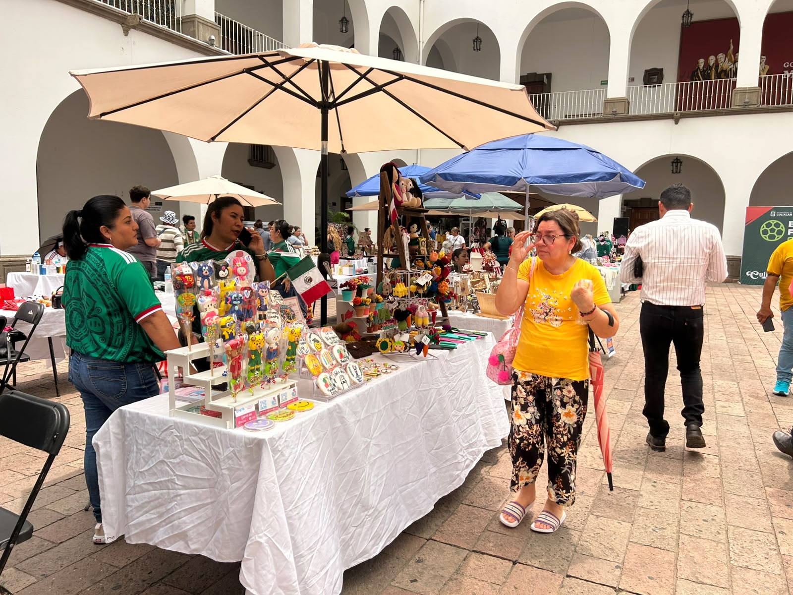 Mujeres vendiendo en mesas y paraguas