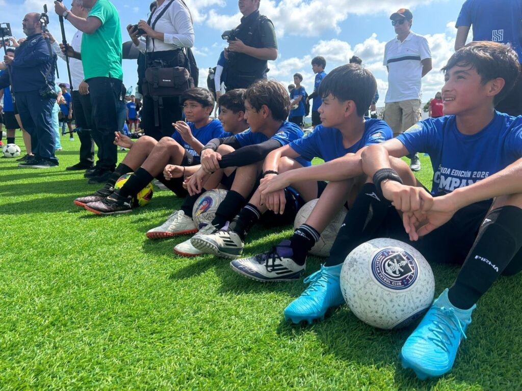 Jugadores sentados en el césped con un balón de futbol