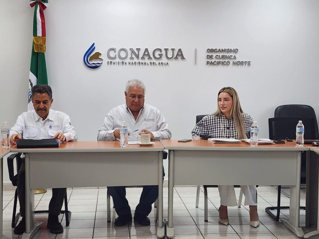 Oficina de Conagua con tres personas sentadas en una mesa