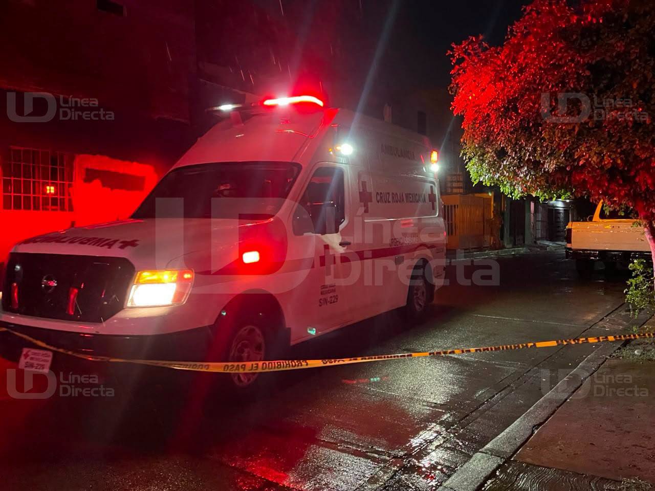 Unidad de la Cruz Roja en una calle con una cinta amarilla de precaución de noche