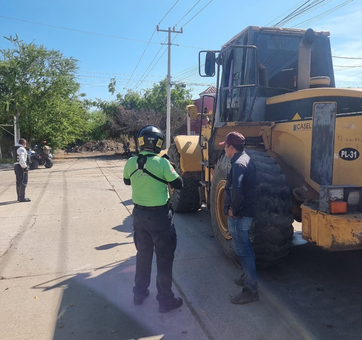 Retroexcavadora con policías