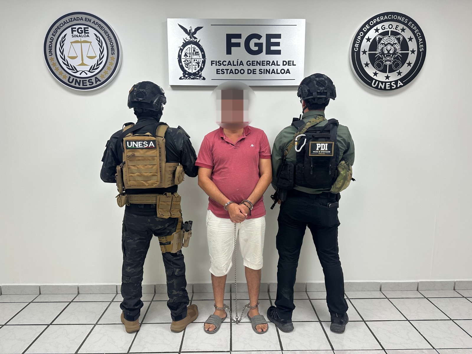 Persona detenida con dos personas de seguridad
