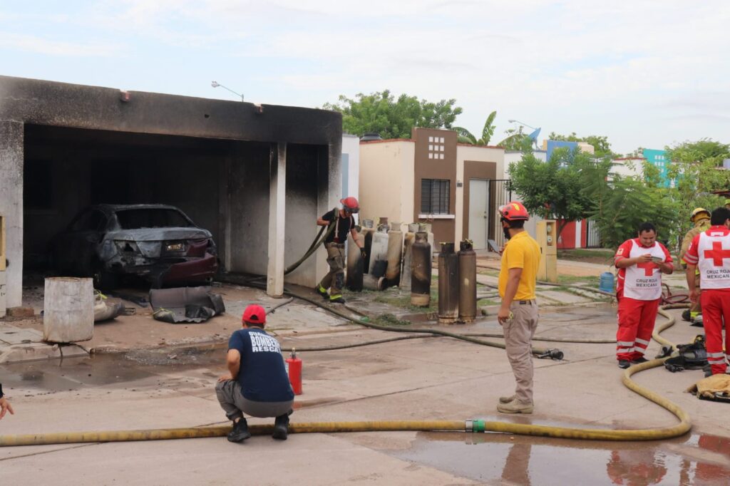 Bomberos y elementos de la cruz roja en una cochera quemada