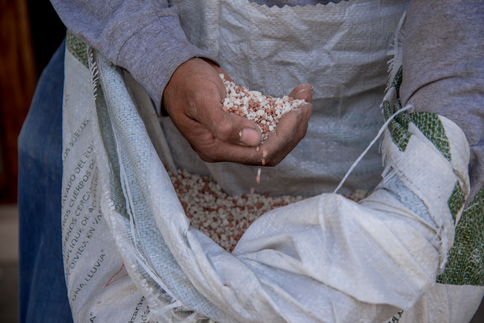 Fertilizante de campo en la mano de una persona